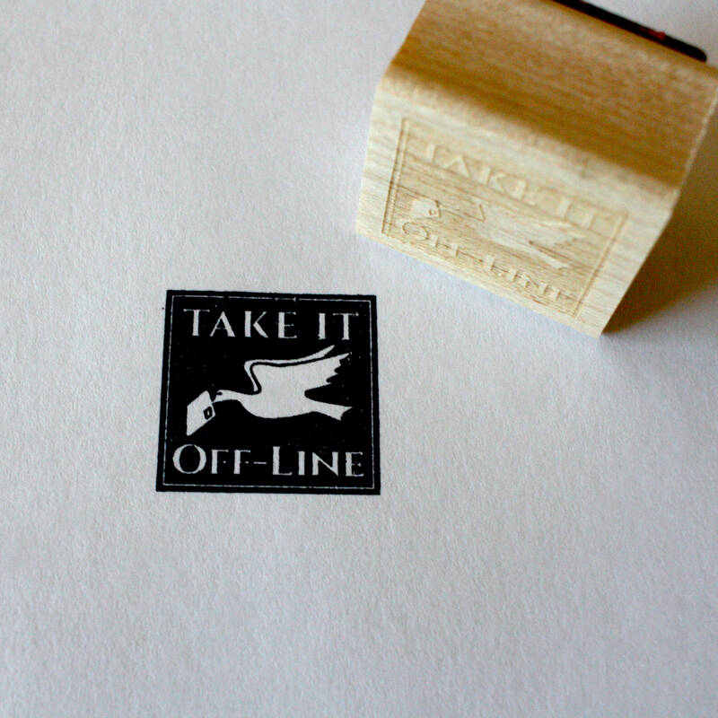 A stamp laying next to it's impression on paper which reads "Take it Offline." It has a bird in flight carrying a snail mail letter in its beak.
