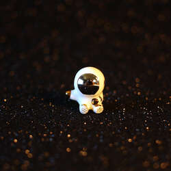 Hand sculpted sitting astronaut figurine with 22k gold and palladium details.