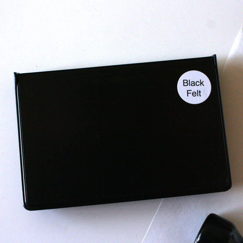 A plain black stamp pad with a sticker reading Black Felt.