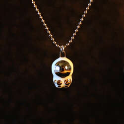 Hand sculpted astronaut with 22k gold and palladium details on a 20 inch stainless steel ball chain necklace.